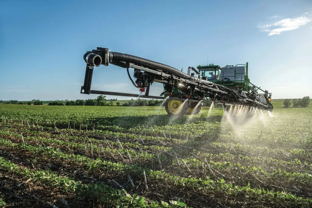 John Deere sprayer applying crop protection with See & Spray technology in a row crop field
