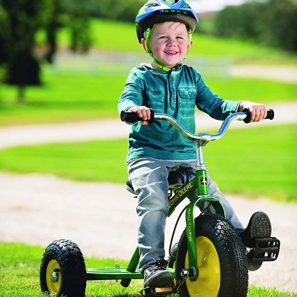 Image of a child riding the John Deere Might Trike kids riding tricycle outside.