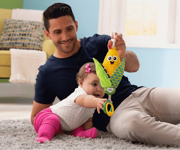 Image of a parent and child playing with the John Deere Lamaze Corn E Cob Clip n Go Infant toy with the ears shucked downward.