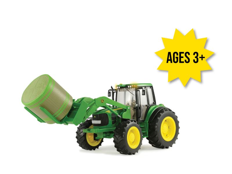 Image of the 1/16 scale John Deere Big Farm Lights & Sounds 7330 Toy tractor with Bale Loader and round bale.