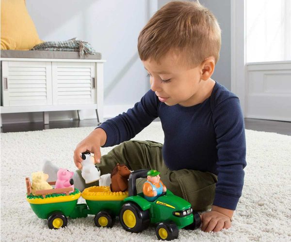 Image of a child playing with the John Deere Animals Sounds Hayride interactive children's toy.