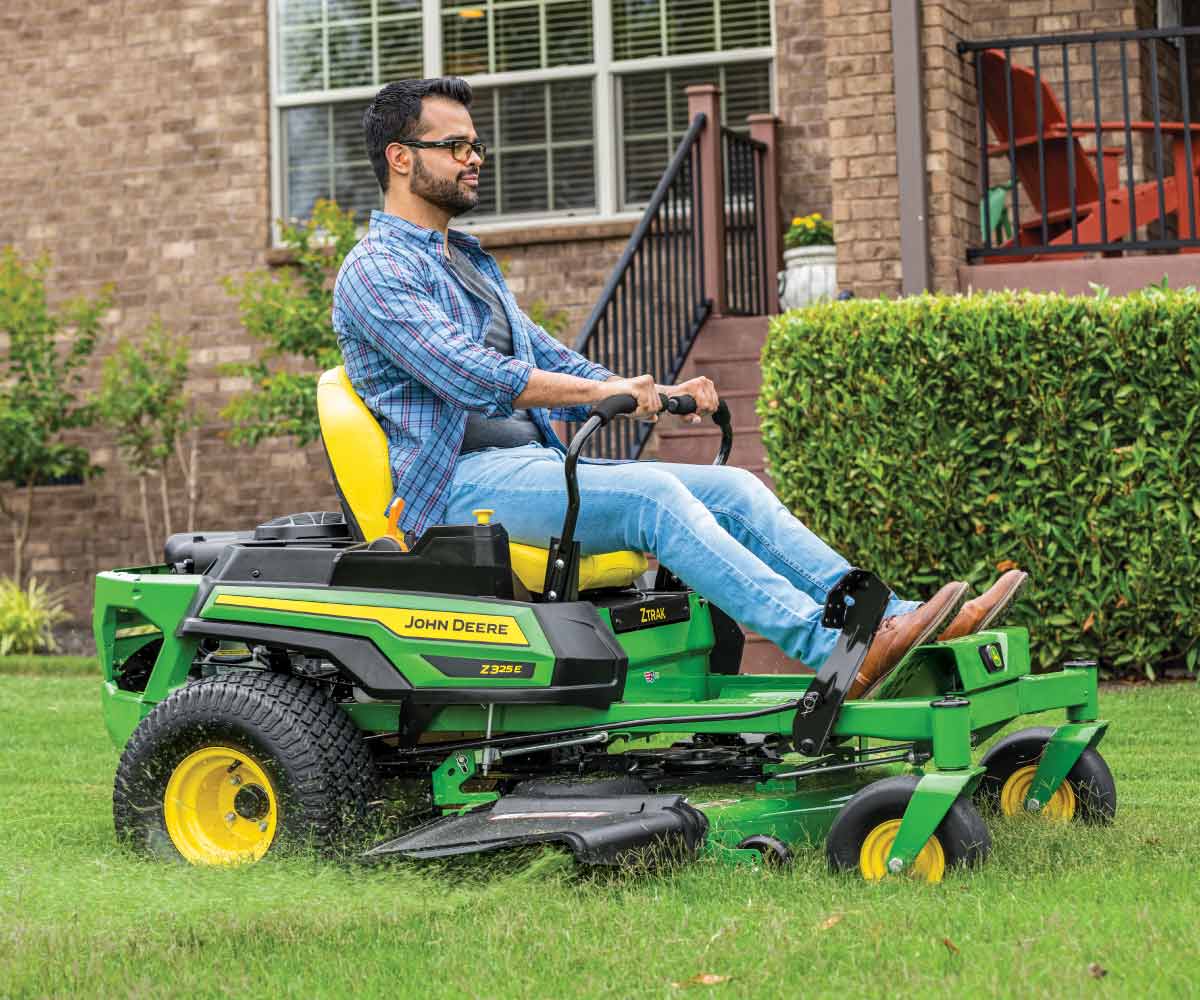 John-Deere-Z325E-Z-Trak-Residental-Zero-Turn-Mower-6 Image of man mowing with Z325E John Deere zero turn mower