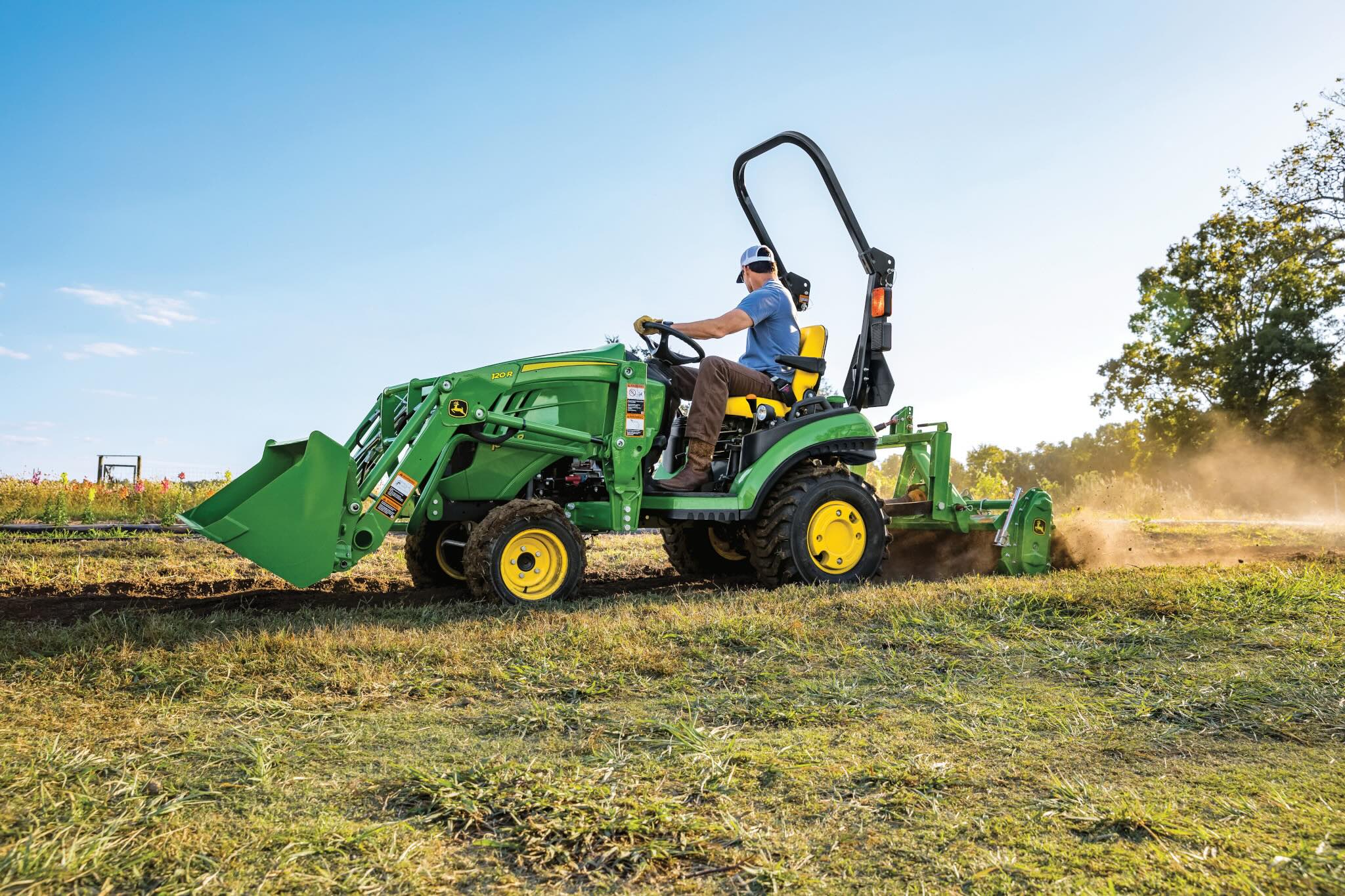 Man driving 1025R tractor with loader in field